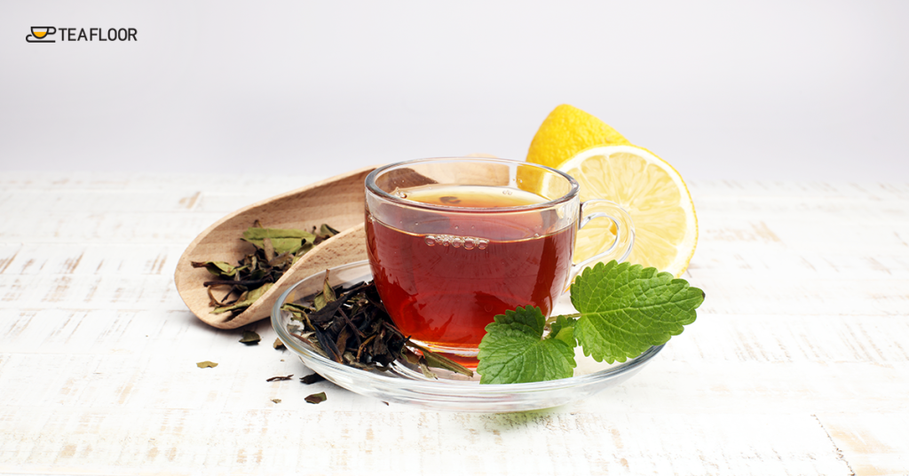 A freshly brewed cup of premium Darjeeling black tea benefits with lemon and mint leaves